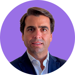 Homem de terno azul com fundo roxo.