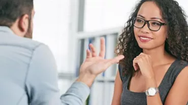 Duas pessoas conversando em um escritório.