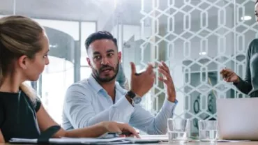 Três pessoas em uma reunião de negócios.