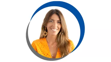 Mulher sorrindo, vestindo camisa laranja, cabelo castanho.