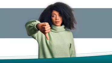 Mulher com suéter verde fazendo gesto de desaprovação.