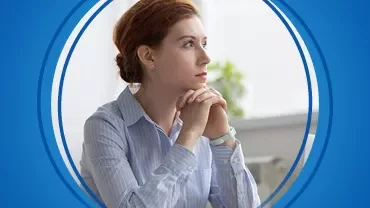 Mulher pensativa em ambiente de trabalho.