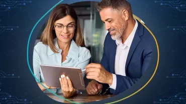 Duas pessoas olhando para um tablet, sorrindo.