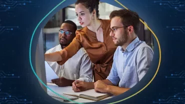 Três pessoas focadas em trabalho colaborativo em frente a um computador.