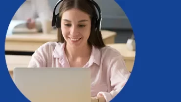Mulher jovem com fones de ouvido usando laptop.
