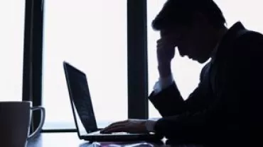 Homem preocupado olhando para laptop.