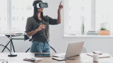 Mulher com óculos de realidade virtual em escritório moderno.