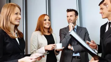 Grupo de profissionais conversando com sorrisos.