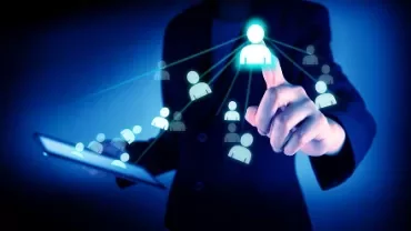 Pessoa tocando ícones de avatares em uma tela digital azul.