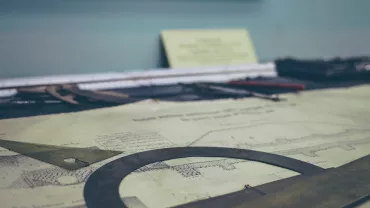 Papel de esboço e instrumentos de desenho sobre a mesa.