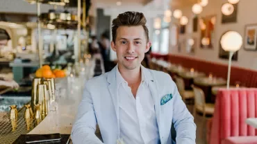 Homem sorridente em um restaurante elegante.
