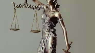 Estátua de bronze de Justiça segurando uma balança.