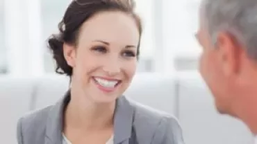 Mulher sorridente conversando com um homem.