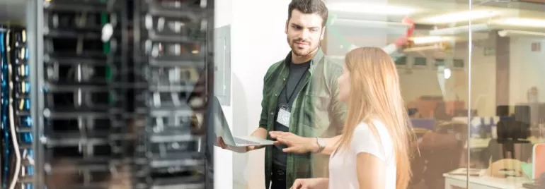 Dois profissionais discutem trabalho em um data center.