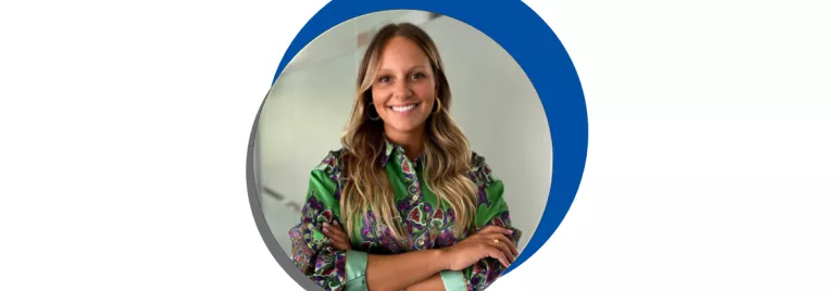 Mulher sorrindo de braços cruzados.