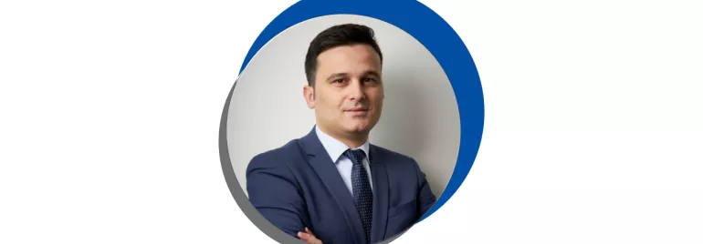 Homem de terno azul em retrato circular com fundo azul e cinza.