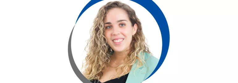 Mulher sorrindo com casaco verde claro e cabelo cacheado.