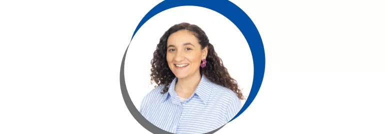 Mulher sorridente com cabelo cacheado em uma moldura circular azul e cinza.