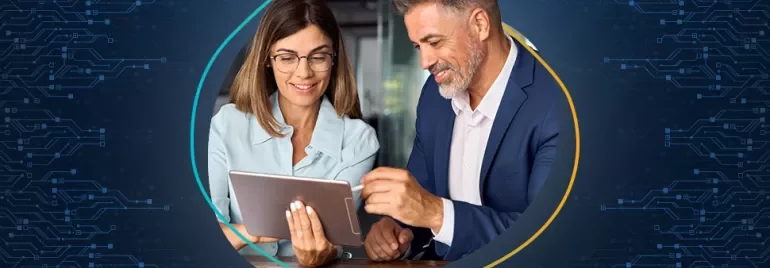 Duas pessoas olhando para um tablet, sorrindo.