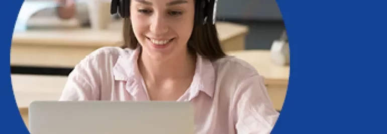 Mulher jovem com fones de ouvido usando laptop.