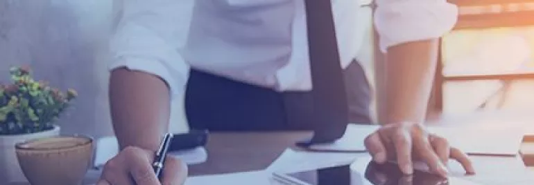 Pessoa em traje social analisando gráficos e usando um tablet.
