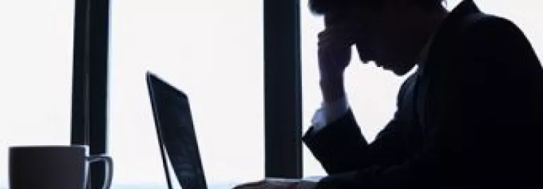 Homem preocupado olhando para laptop.