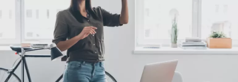 Mulher com óculos de realidade virtual em escritório moderno.