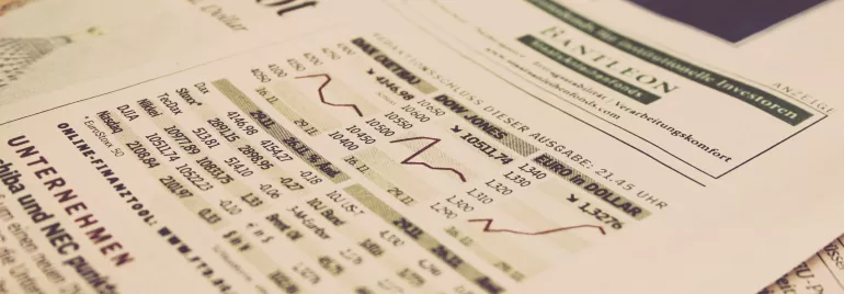 Jornal com gráfico de ações e informações financeiras.