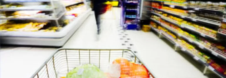 Carrinho de compras com vegetais no supermercado.