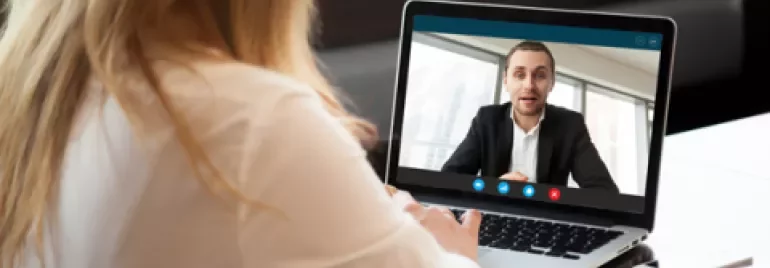 Mulher em videochamada com homem em laptop.