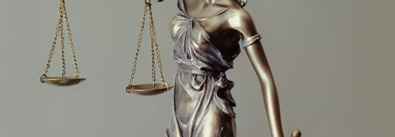 Estátua de bronze de Justiça segurando uma balança.