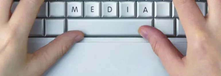 Mãos digitando 'social media' em um teclado.