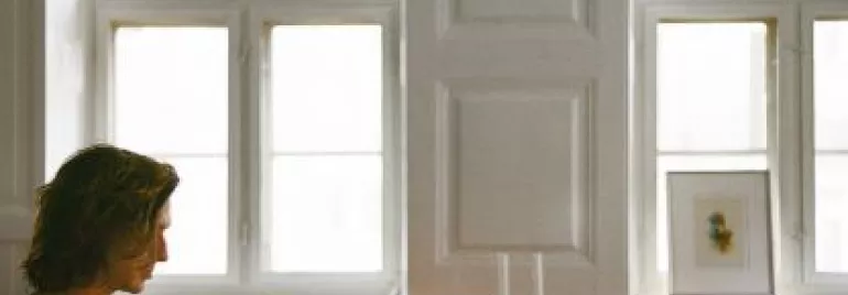 Pessoa em um escritório, trabalhando no laptop em uma mesa.