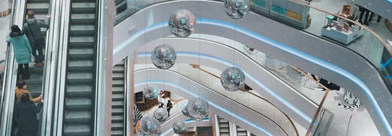 Vista aérea de um shopping com escadas rolantes e decoração moderna em espiral.