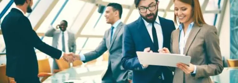 Executivos discutindo relatório em uma sala de reuniões moderna.