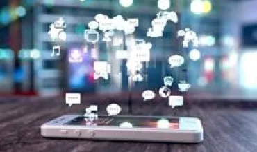 Smartphone em mesa com ícones de aplicativos flutuando acima.
