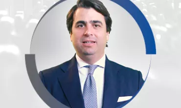 Homem vestindo terno sorrindo, com gráfico circular ao redor.