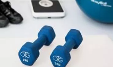 Dois halteres azuis de 2 kg sobre uma superfície branca.