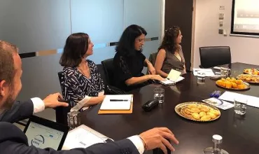 Reunião de negócios com quatro pessoas em uma mesa com lanches.