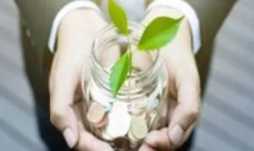 Mãos segurando pote com moedas e planta crescendo