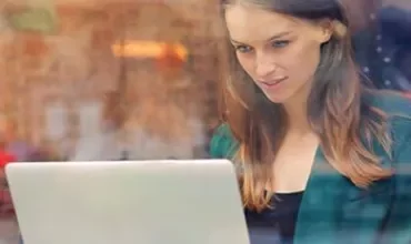 Mulher trabalhando no laptop em uma cafeteria.