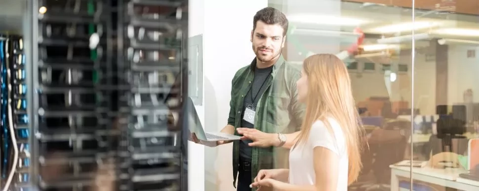 Dois profissionais discutem trabalho em um data center.