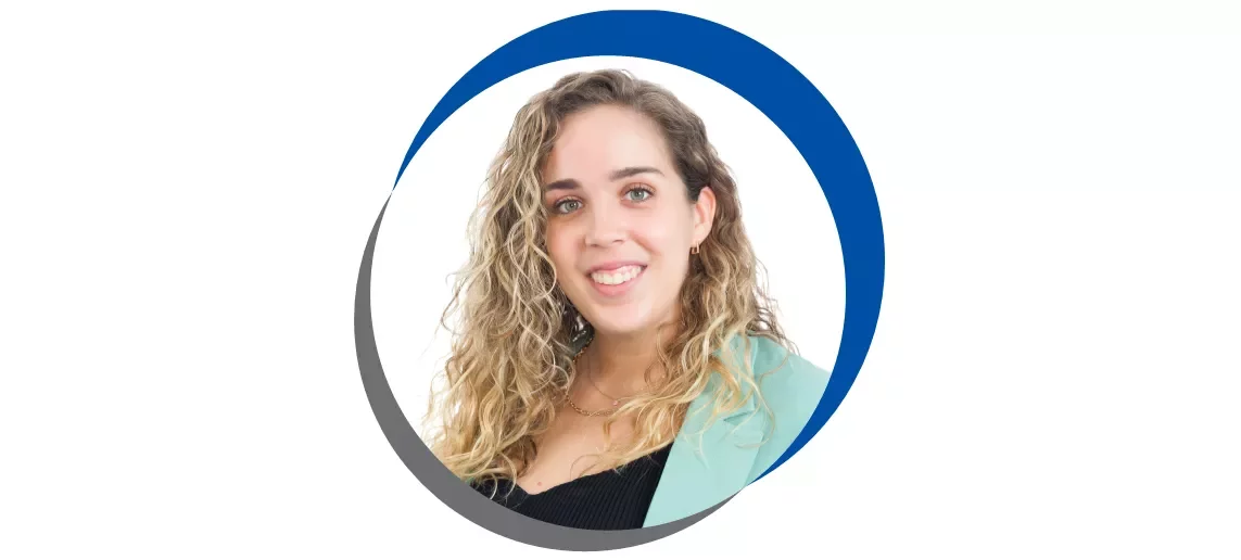 Mulher sorrindo com casaco verde claro e cabelo cacheado.