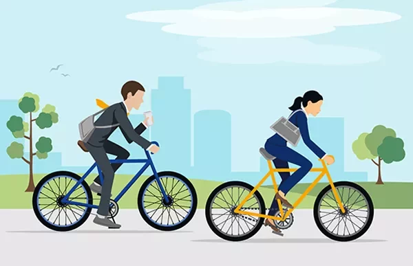 Duas pessoas andando de bicicleta em um parque urbano.