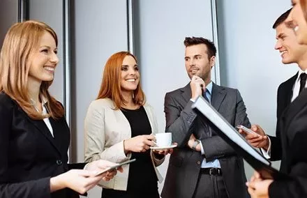 Grupo de profissionais conversando com sorrisos.